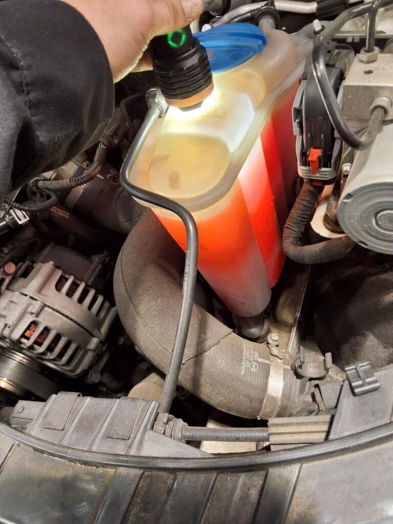 Coolant reservoir being inspected on an Audi Q5.