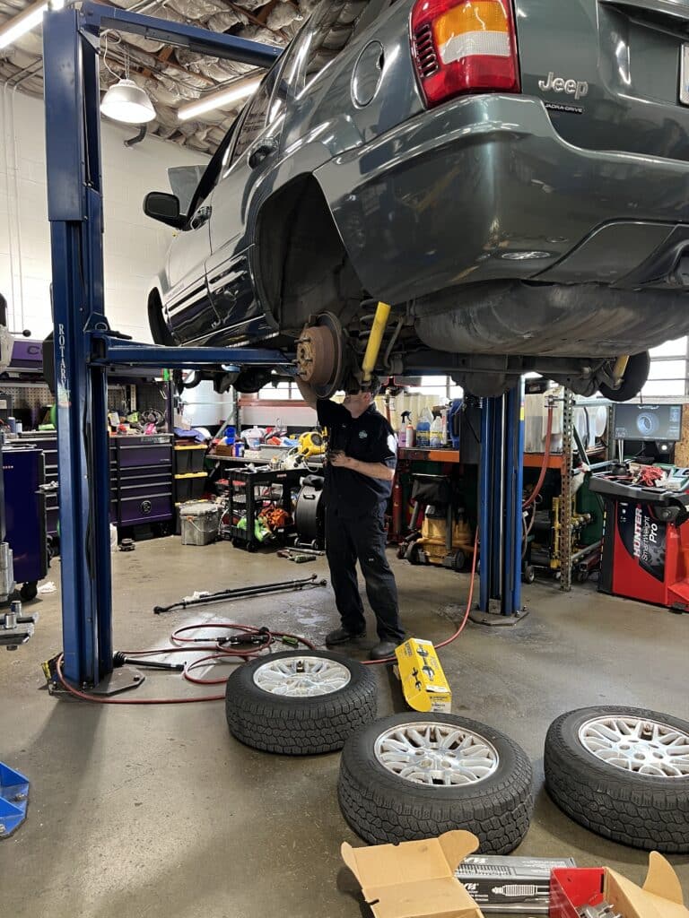 2003 Jeep Grand Cherokee on a lift during front end and driveline repairs at 34th Street Garage.