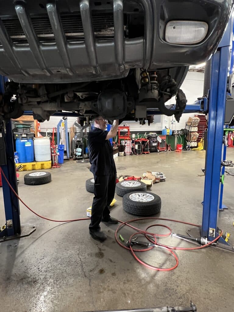 Front axle, steering and suspension area exposed during repairs on a Jeep Grand Cherokee.