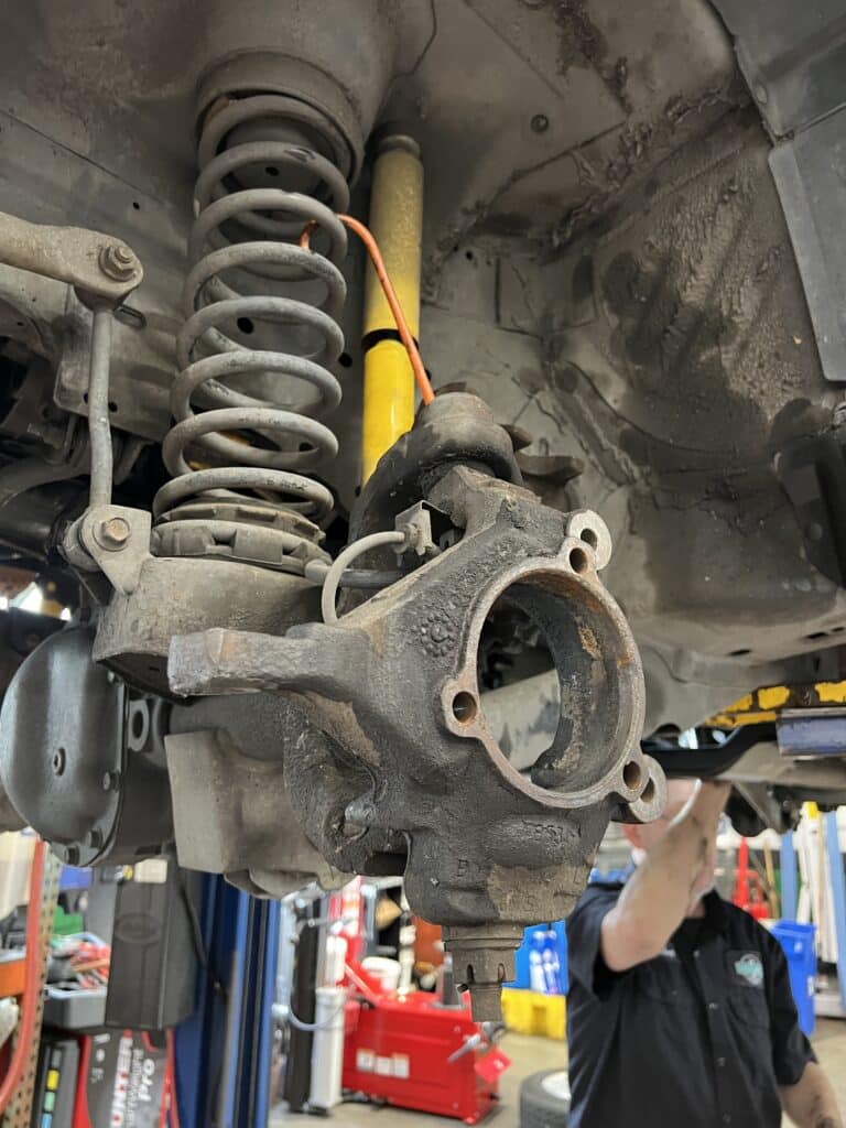 Front steering knuckle and wheel hub area disassembled during repairs on a Jeep Grand Cherokee.