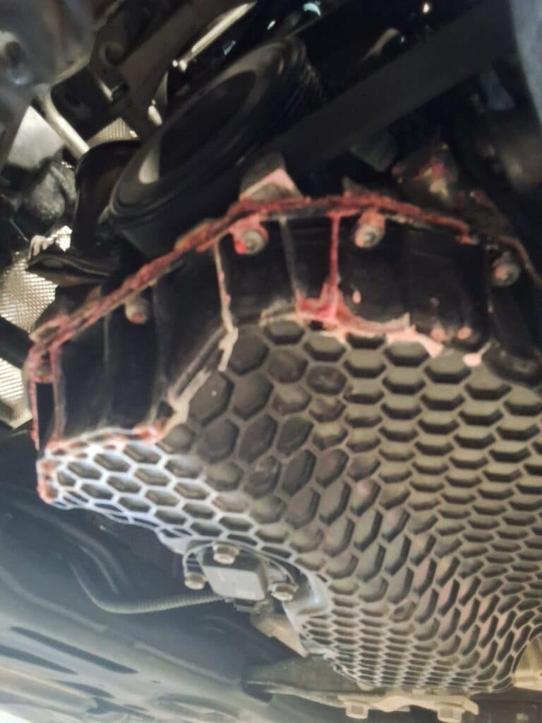 Dried pink coolant residue visible underneath the engine area of a 2021 Volkswagen Tiguan.