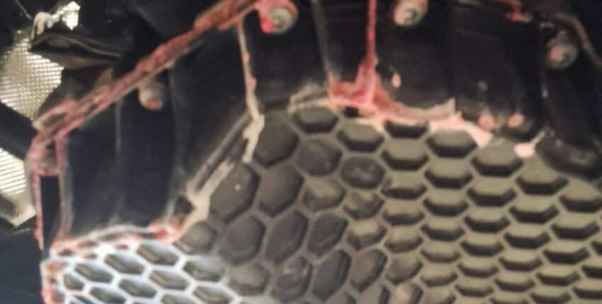 Dried pink coolant residue visible underneath the engine area of a 2021 Volkswagen Tiguan.