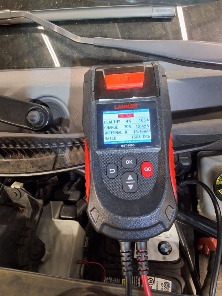 Battery testing performed on a BMW X1 during engine performance diagnosis.