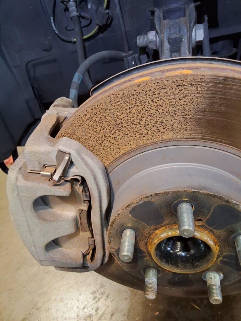 Rusted and pitted front brake rotor on a Scion FR-S during inspection