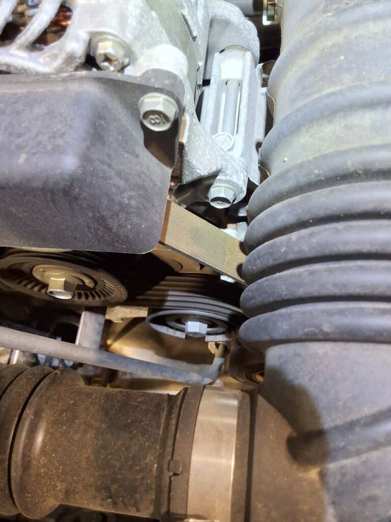 Worn accessory drive belt on a Scion FR-S during inspection.