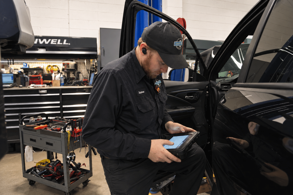 Technician performing vehicle diagnosis at 34th Street Garage in Seattle.