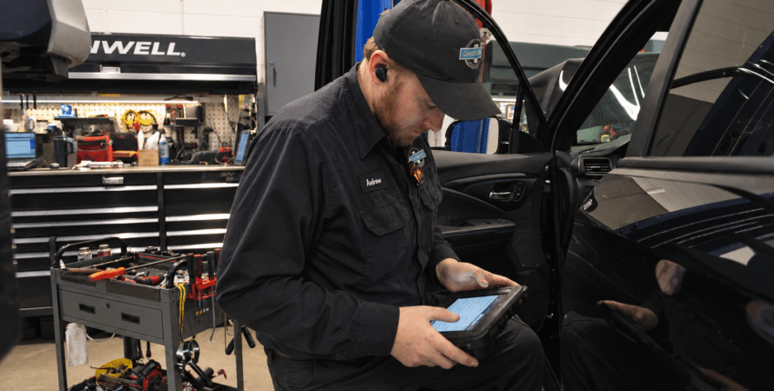 Technician performing vehicle diagnosis at 34th Street Garage in Seattle.