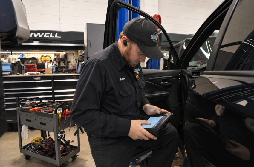 Technician performing vehicle diagnosis at 34th Street Garage in Seattle.