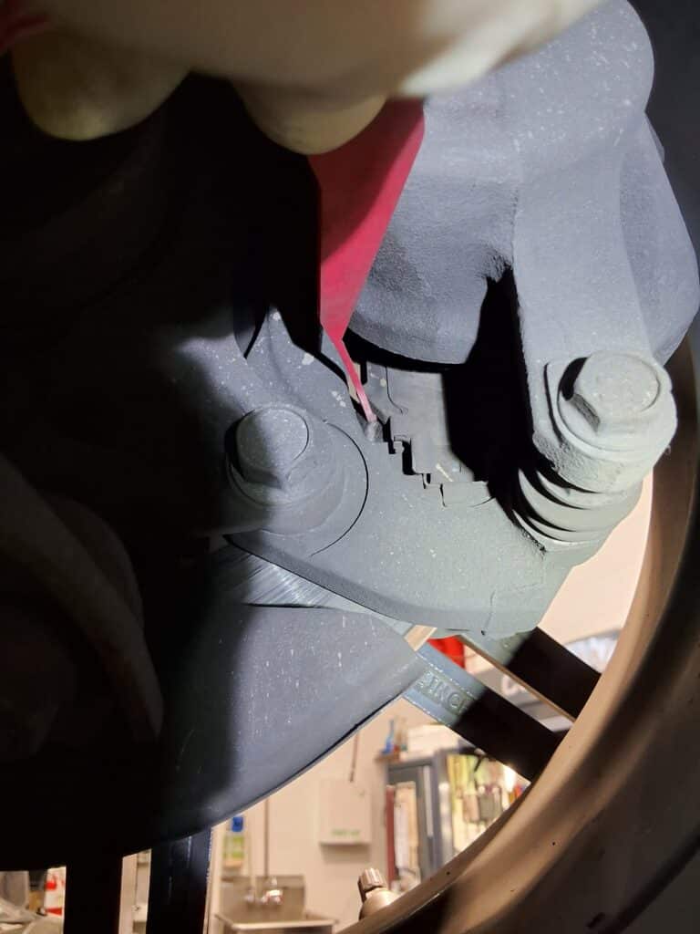 Front brake pad measurement on a Toyota Corolla showing approximately 2 millimeters remaining.